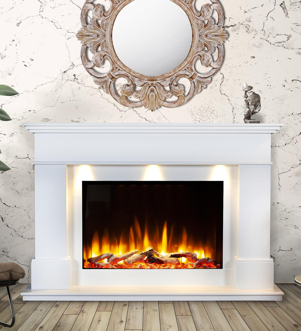 The Celsi Ultiflame VR Adour Aleesia fire in white with a roaring flame effect and three warm downlights. The wall has a marble effect and there is a large, round decorative mirror hanging above the fire. An ornament sits on the mantel. There is a plant next to the fire just visible.