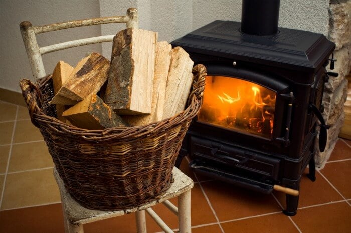 Basket of logs next to a wood burning stove