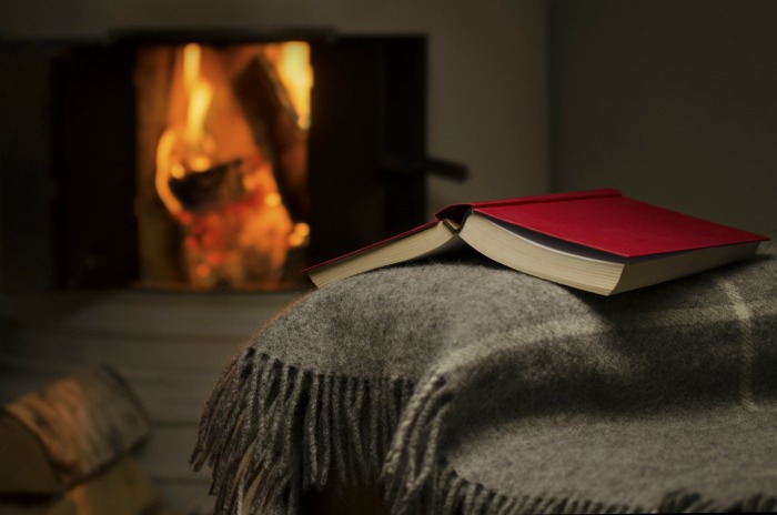 Fireplace with a book on a throw